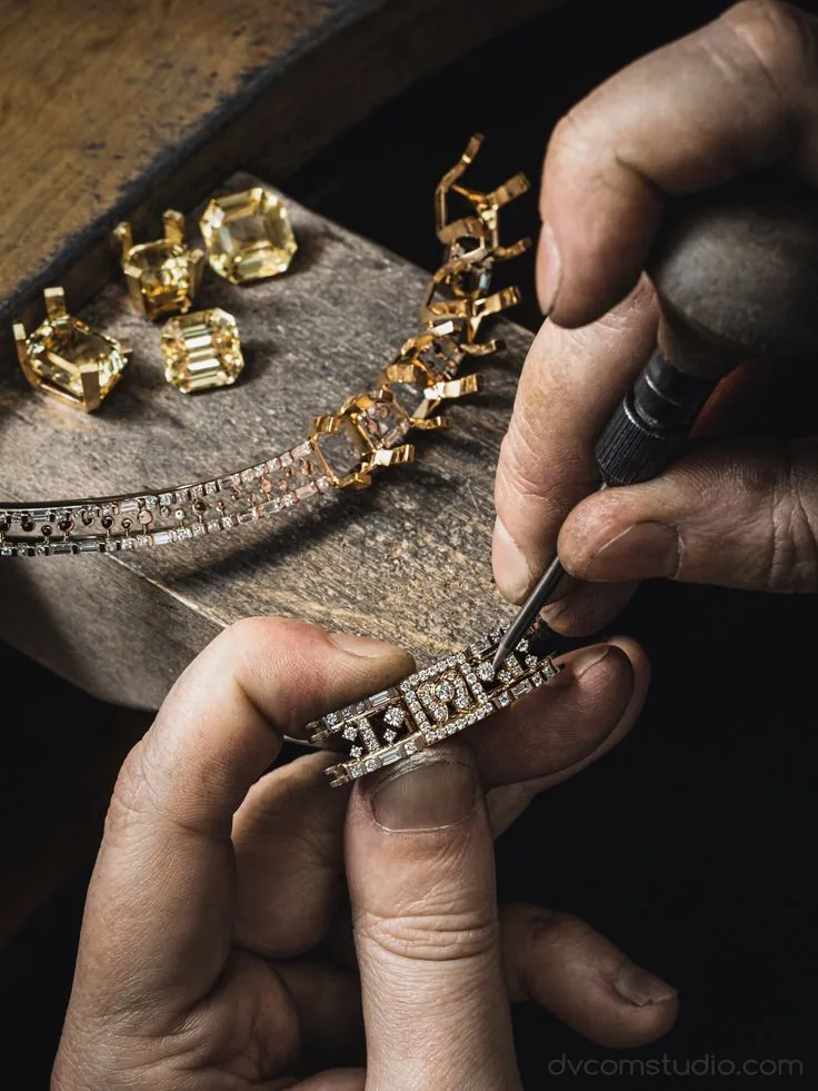A jeweller setting yellow gemstones into a bracelet
